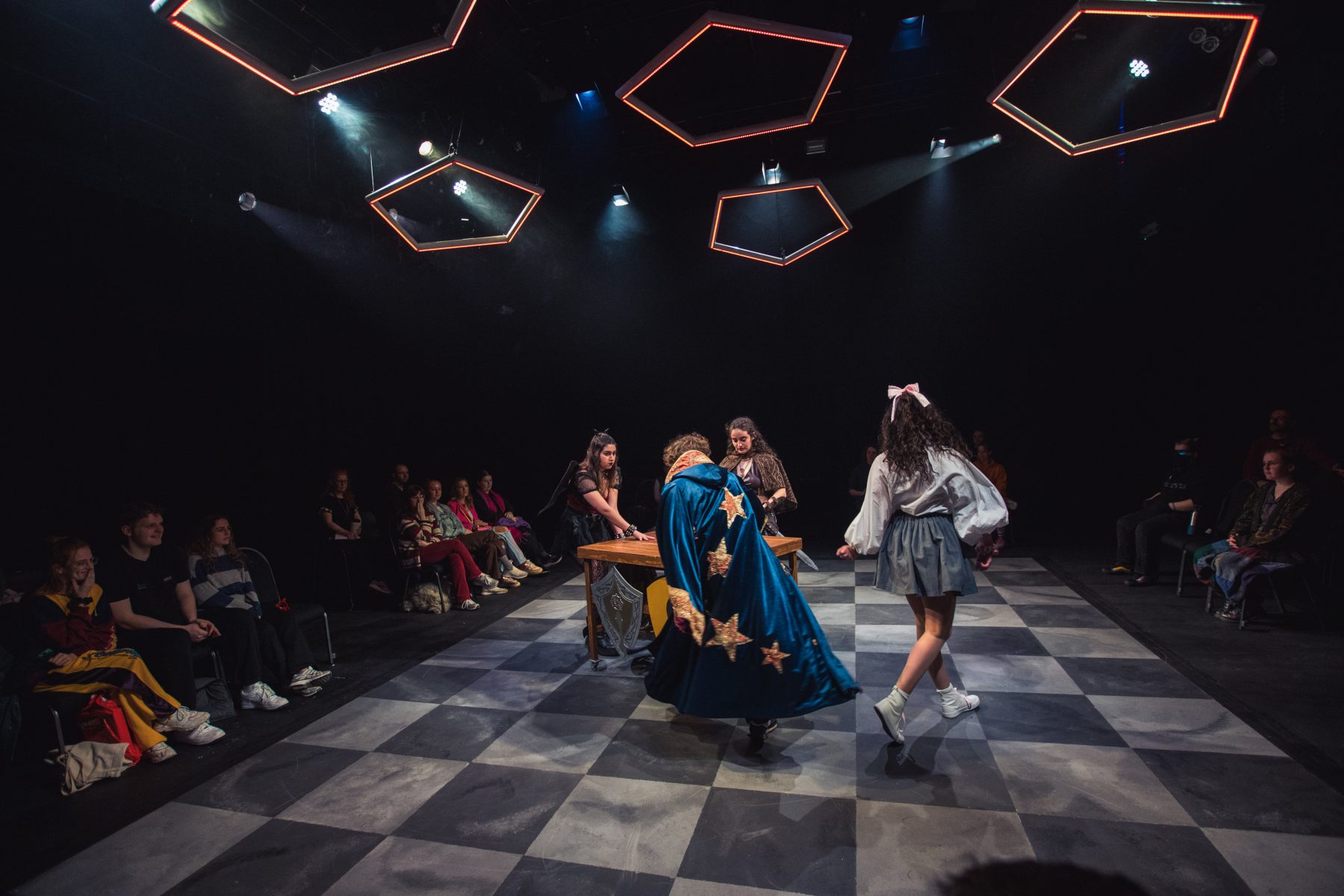 The floor was painted to echo paving slabs, but also a DnD battle map/game board. The roof pieces were inspired by the shape of a D12 die, and a football, working for both shows.